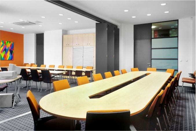 Místnost s velkými oválnými stoly a židlemi